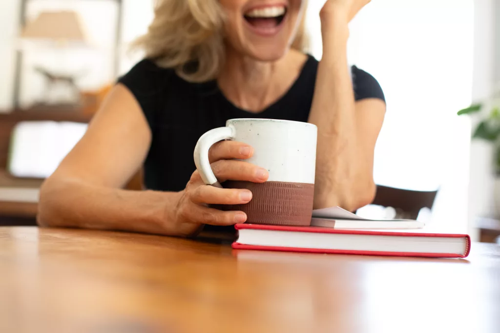 Katherine Faweett holding mug on book